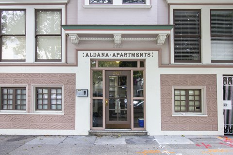 The front of a building with the name "Aldana-Apartments" on the sign above the door.