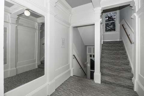 A stairway with a carpeted runner and white walls.