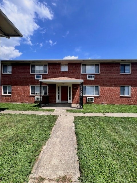 A red brick building with a white door and windows.