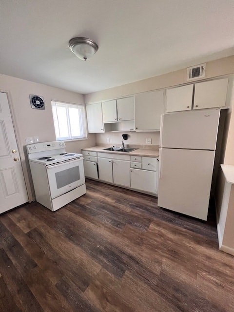 A kitchen with white appliances and wooden floors.