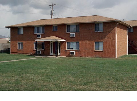 A red brick house with a white door and windows.