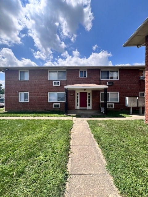 A red brick apartment building with a white door and windows.
