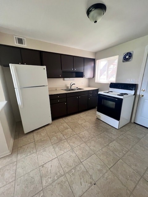 A kitchen with a white refrigerator and black cabinets.