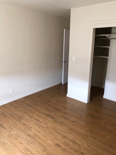 A room with a wooden floor and a white door.